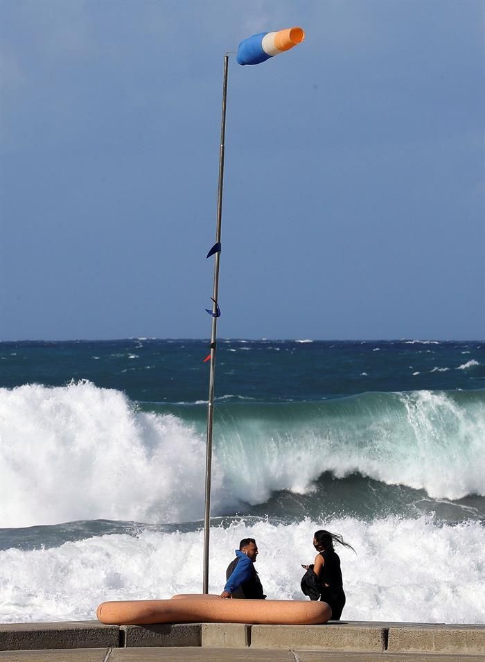 Dos personas observan el oleaje en el paseo de la playa de Las Canteras en Las Palmas de Gran Canaria. EFE/Elvira Urquijo A.