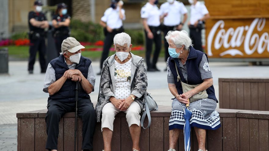 Unos ancianos conversan protegidos con mascarillas este viernes en San Sebastián. EFE/Juan Herrero.
