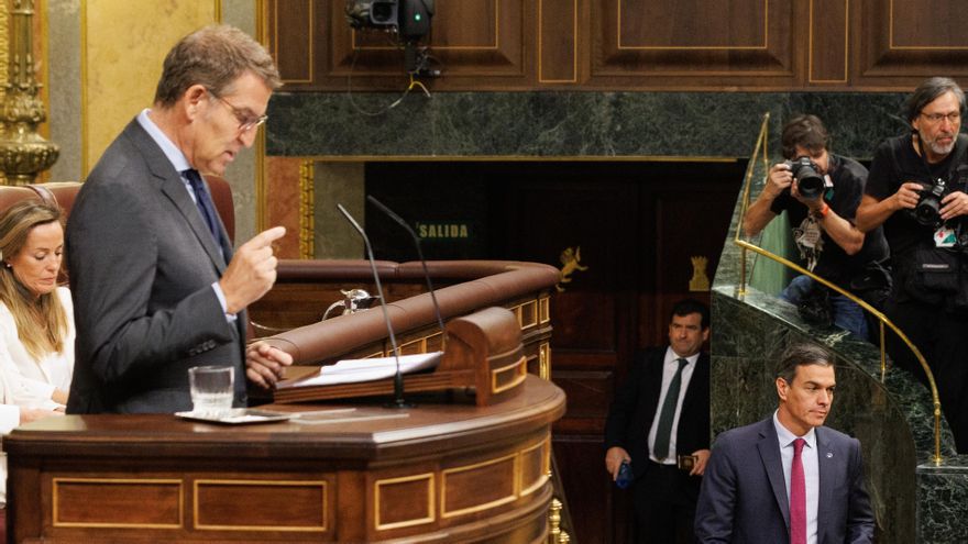 Sánchez pasa junto a la tribuna durante una intervención de Feijóo en el debate de investidura.