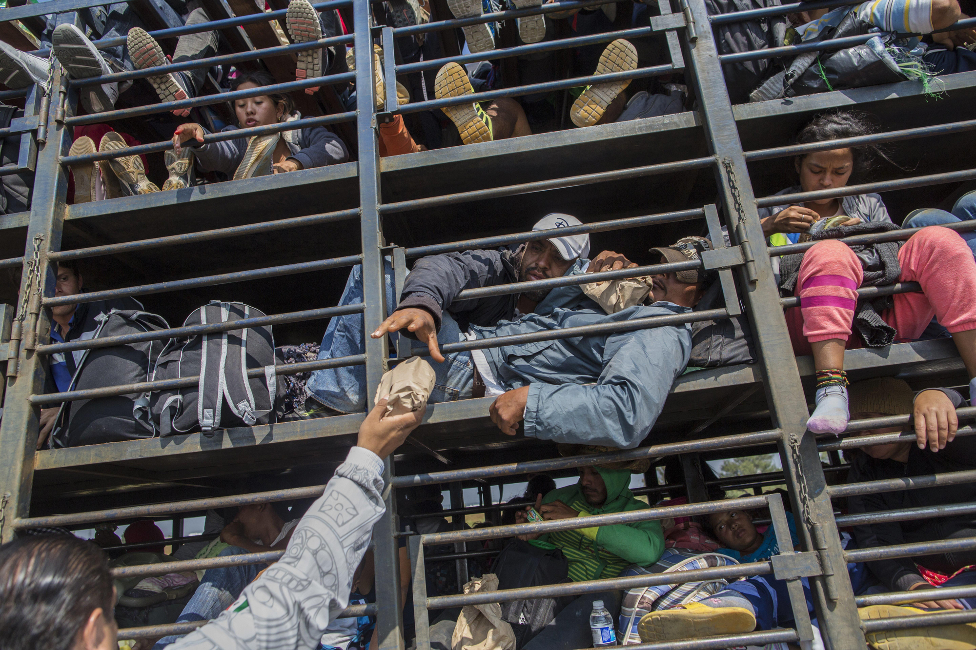Los migrantes centroamericanos, parte de la caravana que espera llegar a la frontera con Estados Unidos, reciben alimentos donados mientras viajan en un camión, en Celaya, México, el domingo 11 de noviembre de 2018. Foto: AP/Rodrigo Abd