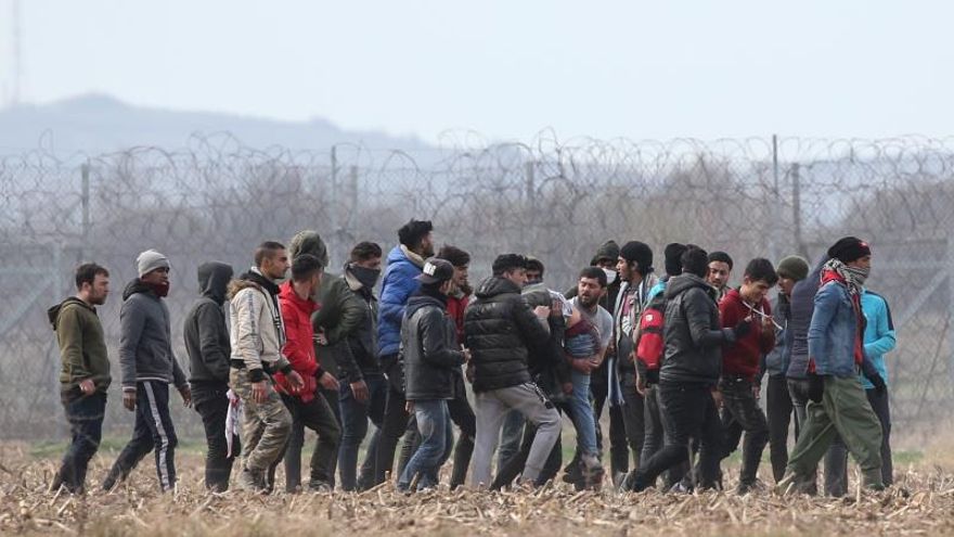 Migrants carry a wounded man and run from tear gas employed by Greek polic officers as they attempt to cross the closed-off Turkish-Greek border in a bid to reach European soil, in Edirne, Turkey, 04 March 2020.
