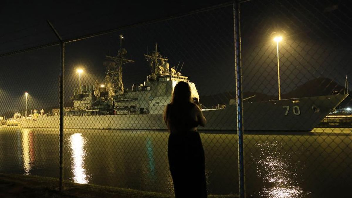 Una persona observa el buque USS Lake Erie (CG-70), en medio del despliegue militar de Estados Unidos en el Caribe, en su transito por el Canal de Panamá, el viernes pasado.