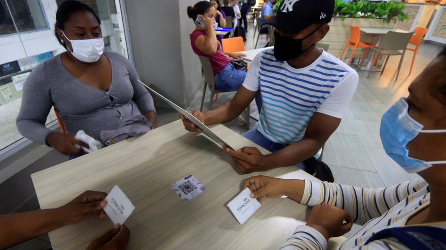 Unos clientes muestran su carnet de vacunación para obtener un descuento en el Restaurante Luigi, en Cartagena de Indias, en una fotografía de archivo. EFE/Ricardo Maldonado Rozo