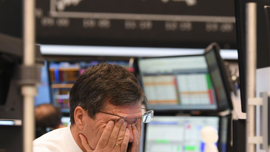 09 March 2020, Hessen, Frankfurt/Main: A stock trader rubs his eyes on the floor of the Frankfurt Stock Exchange. Stock exchanges around the world are reacting with huge losses to the fall in oil prices and concerns about the economic consequences of the