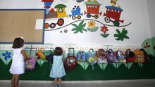 Dos niñas frente a las perchas de una escuela de Córdoba. / EFE