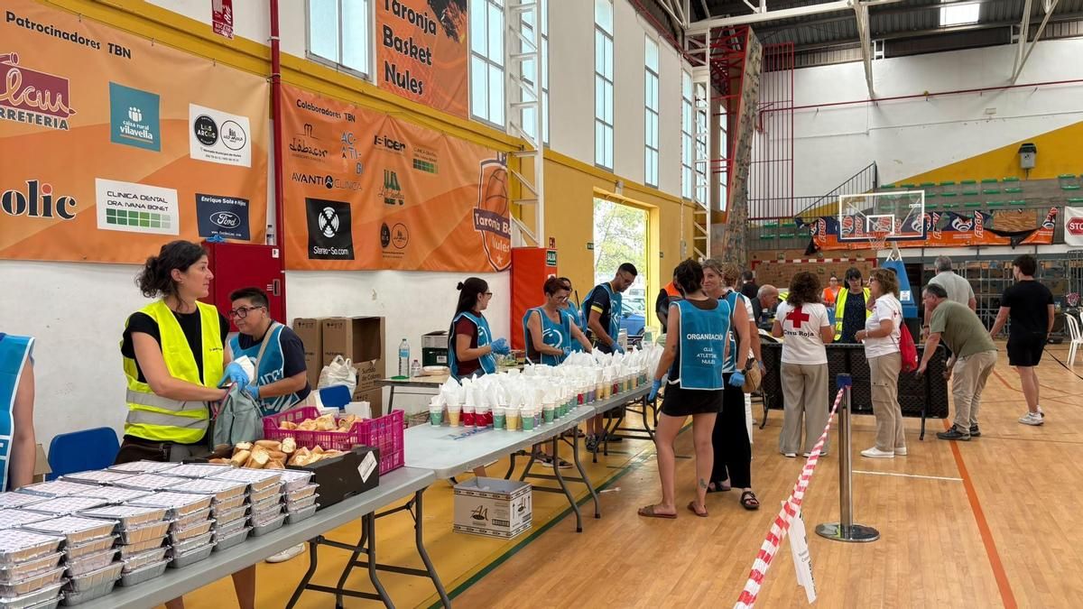 Los voluntarios preparan la comida para los desalojados en el polideportivo de Nules.