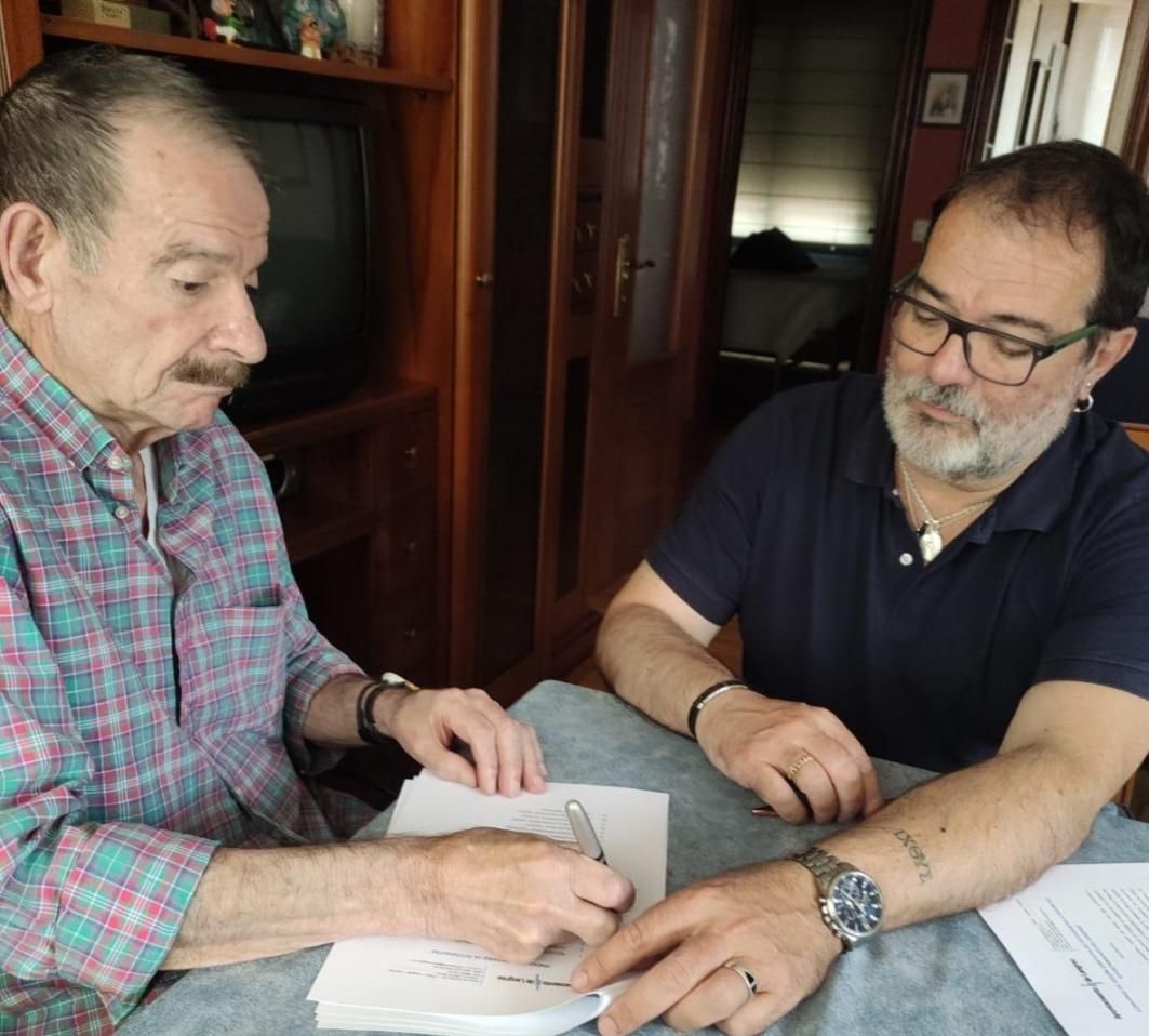 El expolítico, exsindicalista y exminero, Gerardo Iglesias, a la izquierda, firma la cesión de 134 docuentos de su archivo personal junto al alcalde de Langreo, Roberto Marcos García.