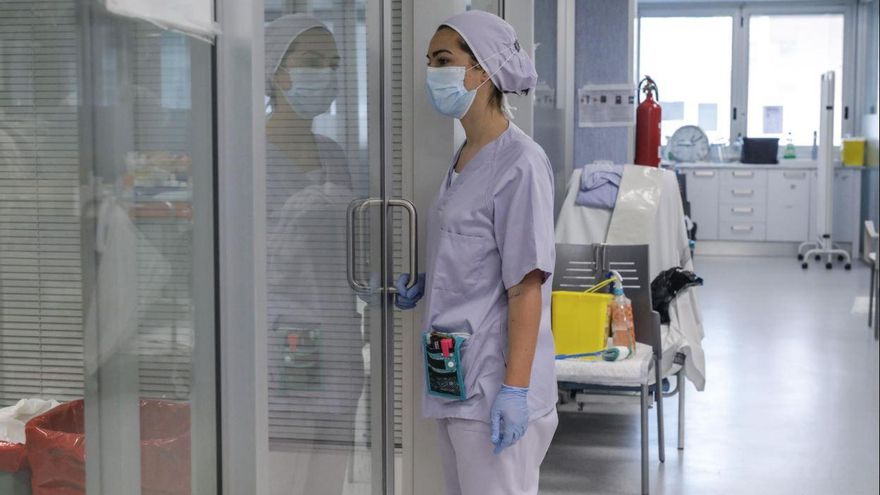 Trabajadores sanitarios totalmente protegidos atienden a un paciente con coronavirus ingresado en la UCI del Hospital Arnau de Vilanova.