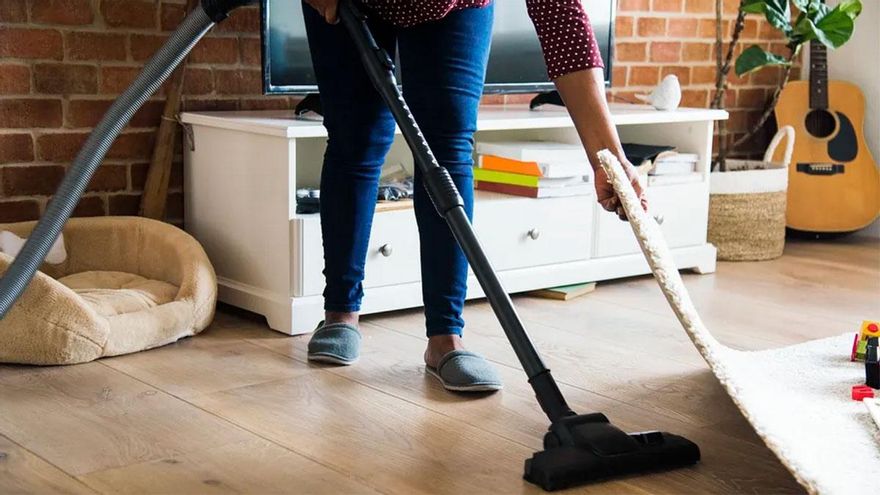 Una empleada de hogar pasando la aspiradora