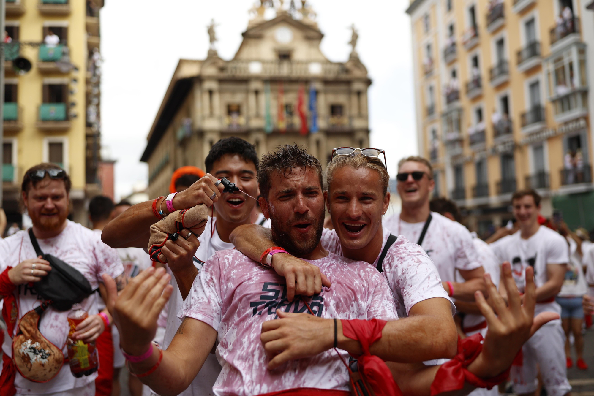 Un grupo de turistas celebra el inicio de las fiestas de San Fermín en la Plaza Consistorial de Pamplona. EFE