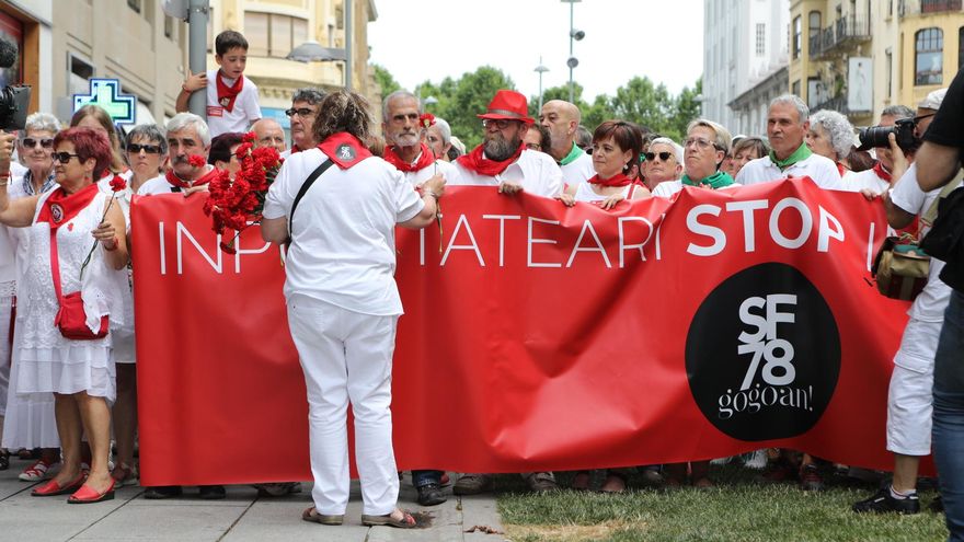 Archivo - Una mujer reparte claveles rojos a los asistentes al homenaje a Germán Rodríguez, fallecido por disparos de la policía en los Sanfermines de 1978 en Pamplona.