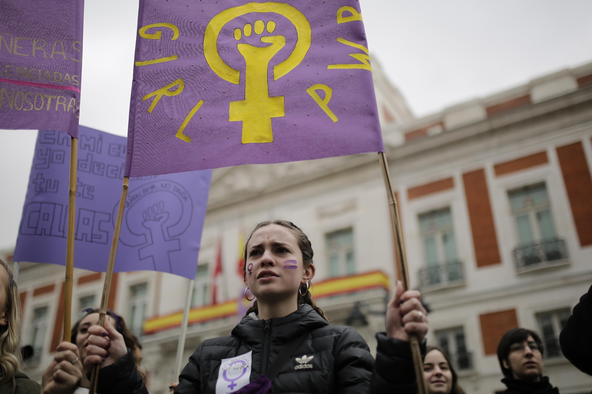 Una feminista sostiene una pancarta en la que se lee "Girl Power" en la Puerta del Sol.