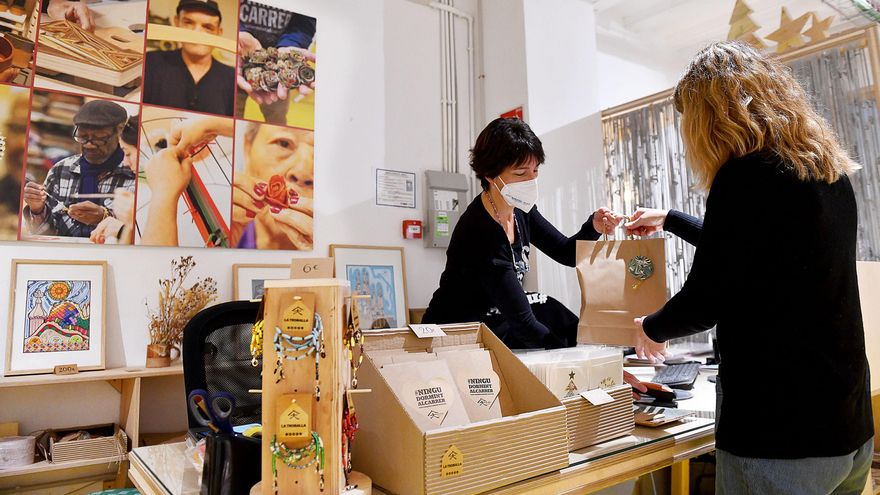 Una mujer compra un regalo en 'La Troballa', la tienda de Arrels