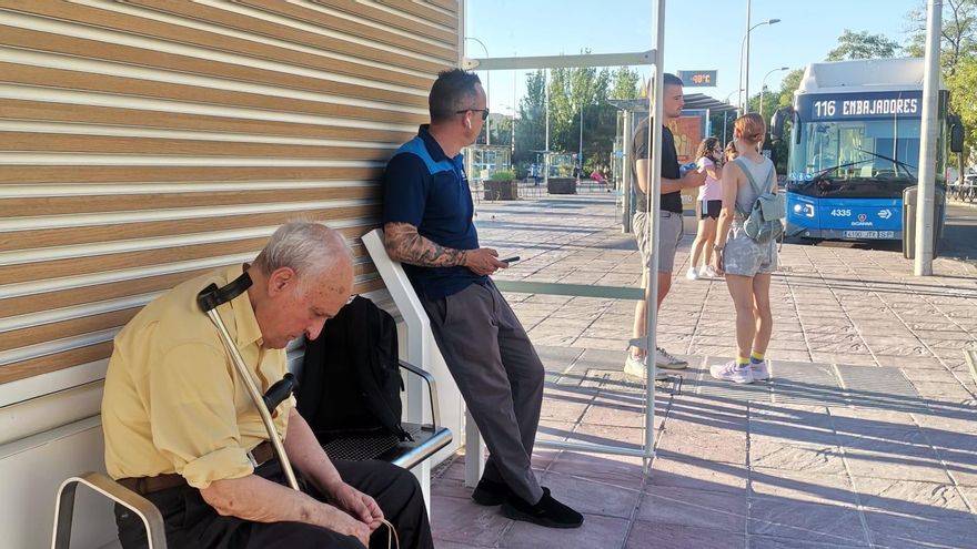 Un conductor de la EMT y un anciano esperando en la marquesina en julio de 2024, días después de su instalación