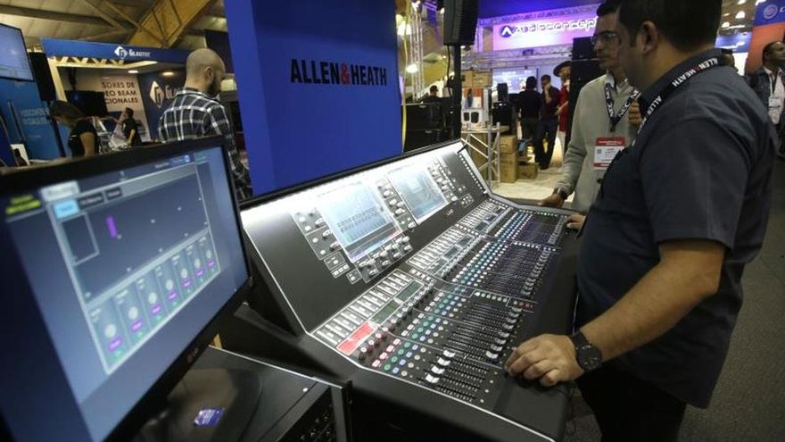 Un hombre maneja una consola de sonido.