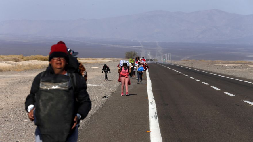 Migrantes de Venezuela caminan sobre el arcén de una carretera después de cruzar a Chile desde la frontera con Bolivia, cerca de Colchane, Chile, el sábado 2 de febrero.