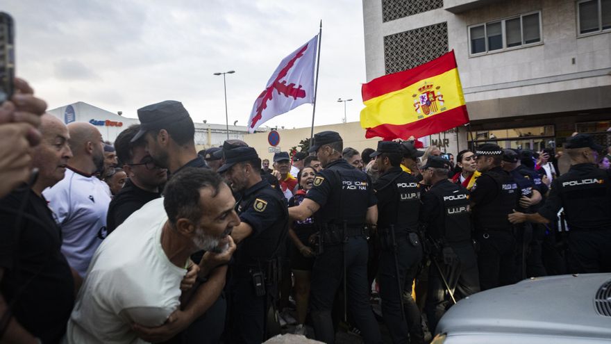 Agentes de la Policía Nacional tratan de frenar a los ceutíes concentrados a la entrada del puerto de Ceuta.