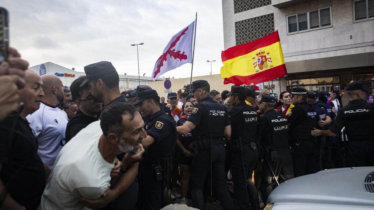 Agentes de la Policía Nacional tratan de frenar a los ceutíes concentrados a la entrada del puerto de Ceuta.