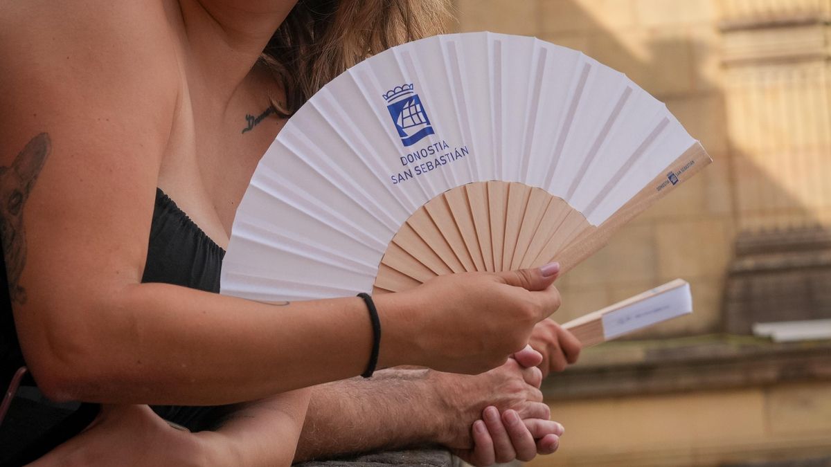 Una mujer se abanica en las fiestas de Donostia