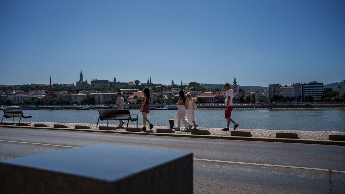Varias personas pasean al lado del río Danubio, que atraviesa Budapest.