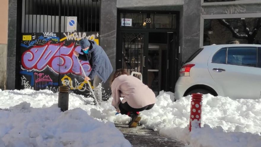 Una pareja abre un camino en la plaza Guardia de Corps, entre Conde Duque y Limón