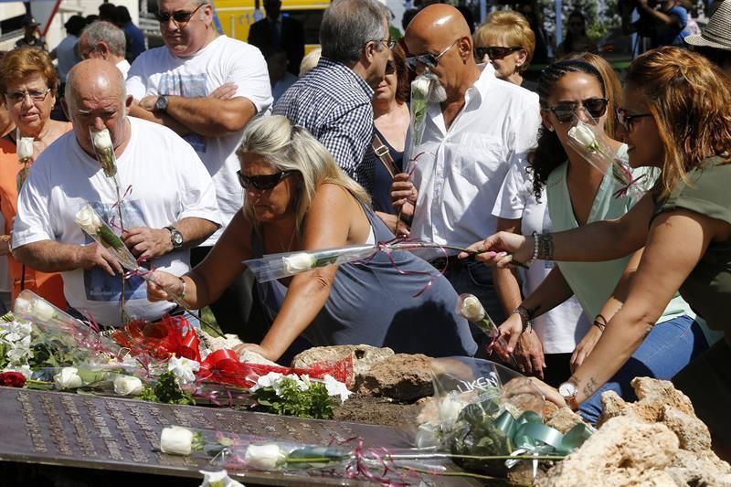 Familiares y amigos colocan flores junto al pie del Olivo en los jardines de entrada a la Terminal. EFE/Chema Moya