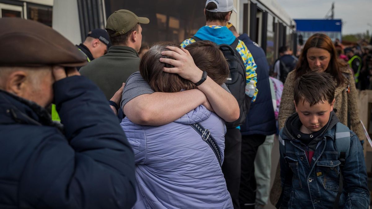 Refugiados se abrazan hoy tras llegar al estacionamiento de un centro comercial en Zaporiyia (Ucrania). La viceprimera ministra de Ucrania, Iryna Vereshchuk, anunció este martes el éxito de la "primera parte" de la operación para rescatar de la acería de Azovstal a un convoy con cerca de 150 mujeres, ancianos y niños que, según dijo, llegarán pronto a Zaporiyia.