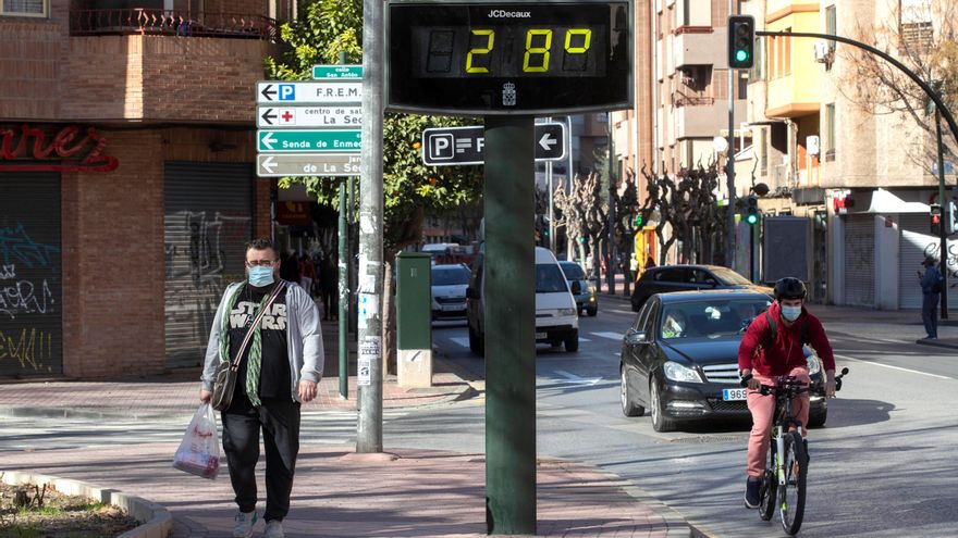 Un hombre camina junto a un termómetro que marca 28 grados centígrados este jueves en Murcia. EFE/Marcial Guillén