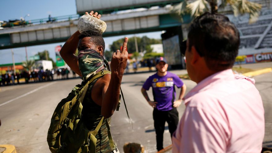 Un migrante haitiano durante una protesta en México hace un gesto a un conductor enfadado