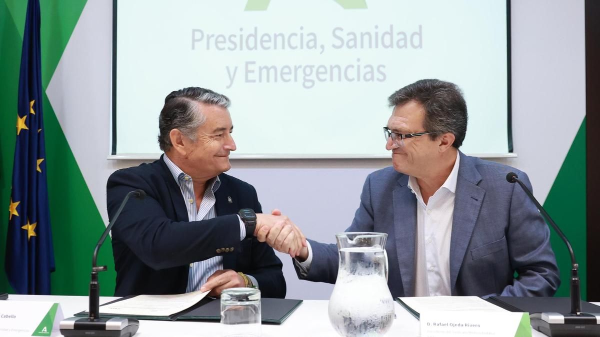 Antonio Sanz y Rafael Ojeda se saludan tras firmar el acuerdo.