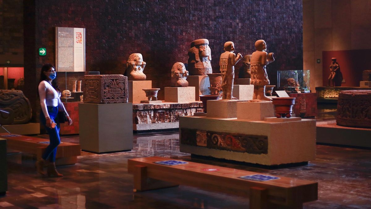 Una mujer visita una sala de exposición del Museo Antropológico de México. 