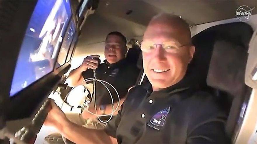 A handout video-grabbed still image made available by NASA on 31 May 2020 shows NASA astronauts Doug Hurley (foreground) and Bob Behnken call down to mission controllers for a report on their second flight day onboard the SpaceX Crew Dragon spacecraft on NASA's SpaceX Demo-2 mission approaching to dock to the International Space Station (ISS), 31 May 2020.