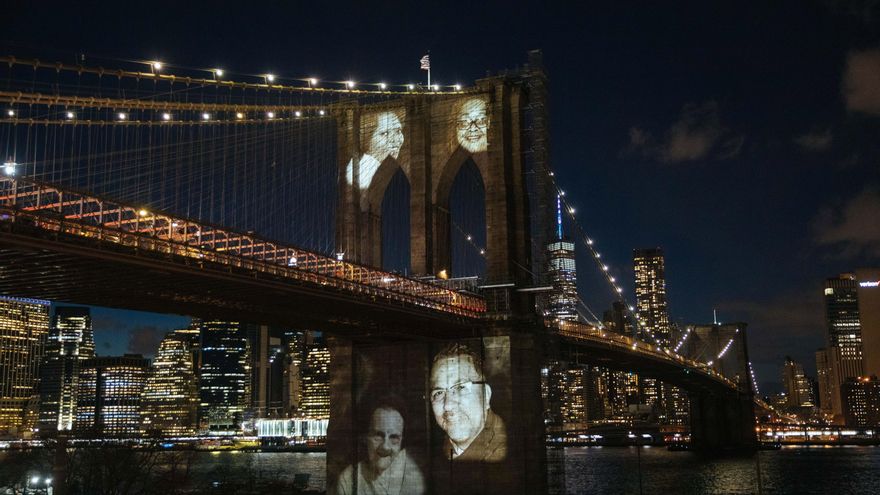 Imágenes de personas que murieron por complicaciones relacionadas con la enfermedad covid-19 fueron proyectadas este domingo sobre el Puente de Brooklyn, durante una ceremonia conmemorativa para recordar a las más de 30.000 víctimas de la pandemia en la "gran manzana", en el distrito de Brooklyn (NY, EE.UU.).