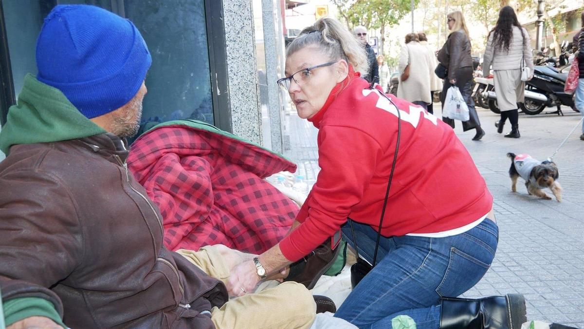 Una voluntaria de Cruz Roja atiende a una persona sin hogar.