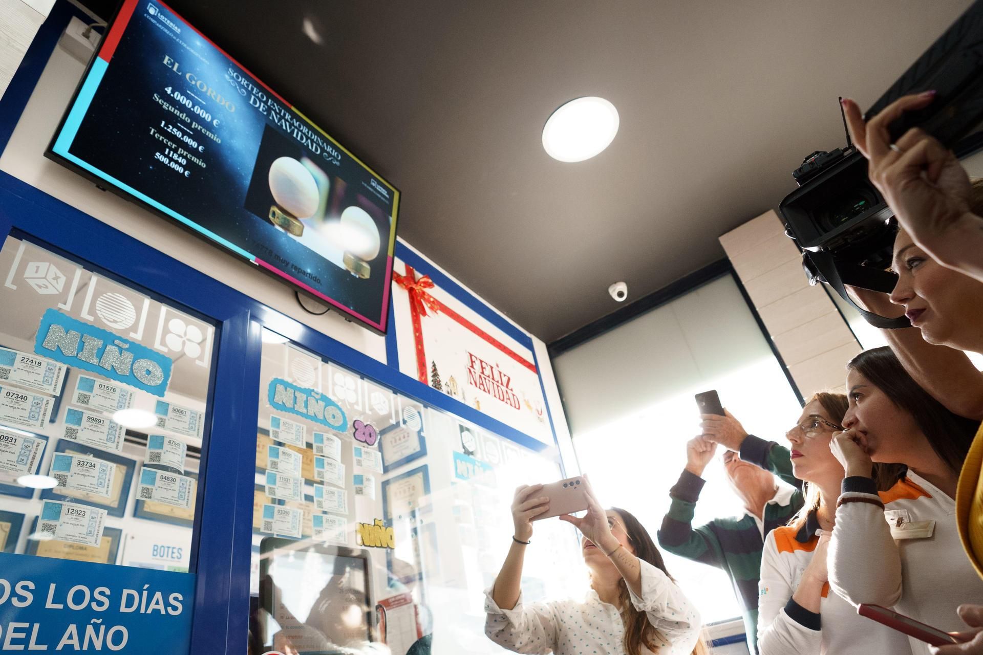 Empleados y propietarios de la gasolinera La Chasnera celebran los premios de varios de los números vendidos en su establecimiento, agraciados con un tercero, un cuarto y un quinto premio en el sorteo extraordinario de Navidad de la Lotería Nacional. EFE/Ramón de la Roch