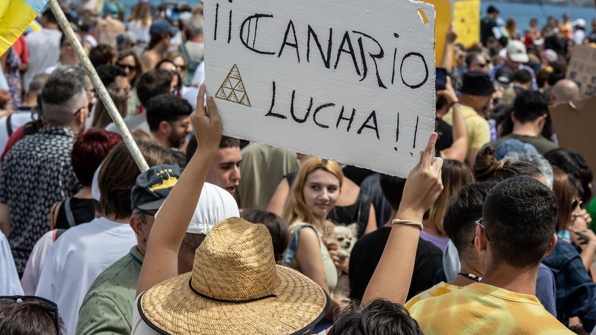 Una persona sujeta un cartel de protesta durante una manifestación contra el modelo turístico, a 20 de abril de 2024, en Las Palmas de Gran Canaria.