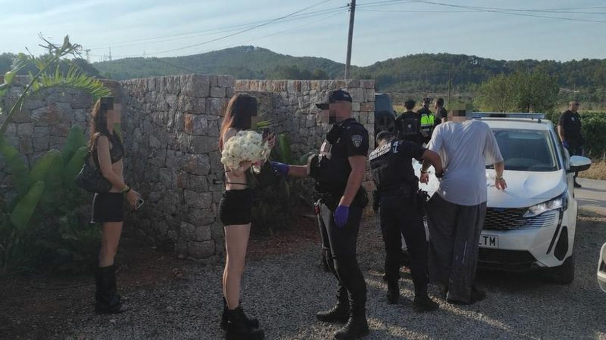 Un agente de la Policía Local realiza un control a una de las asistentes a la fiesta ilegal de Santa Getrudis
