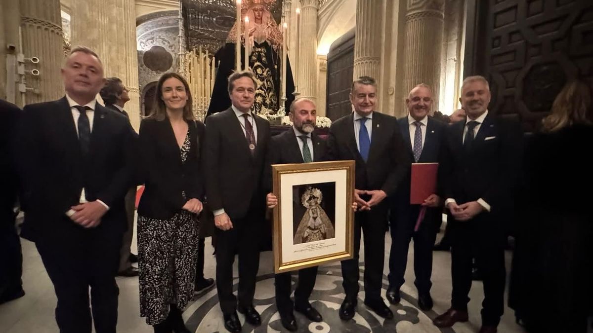 Autoridades y miembros de la hermandad, con un cuadro de la imagen.