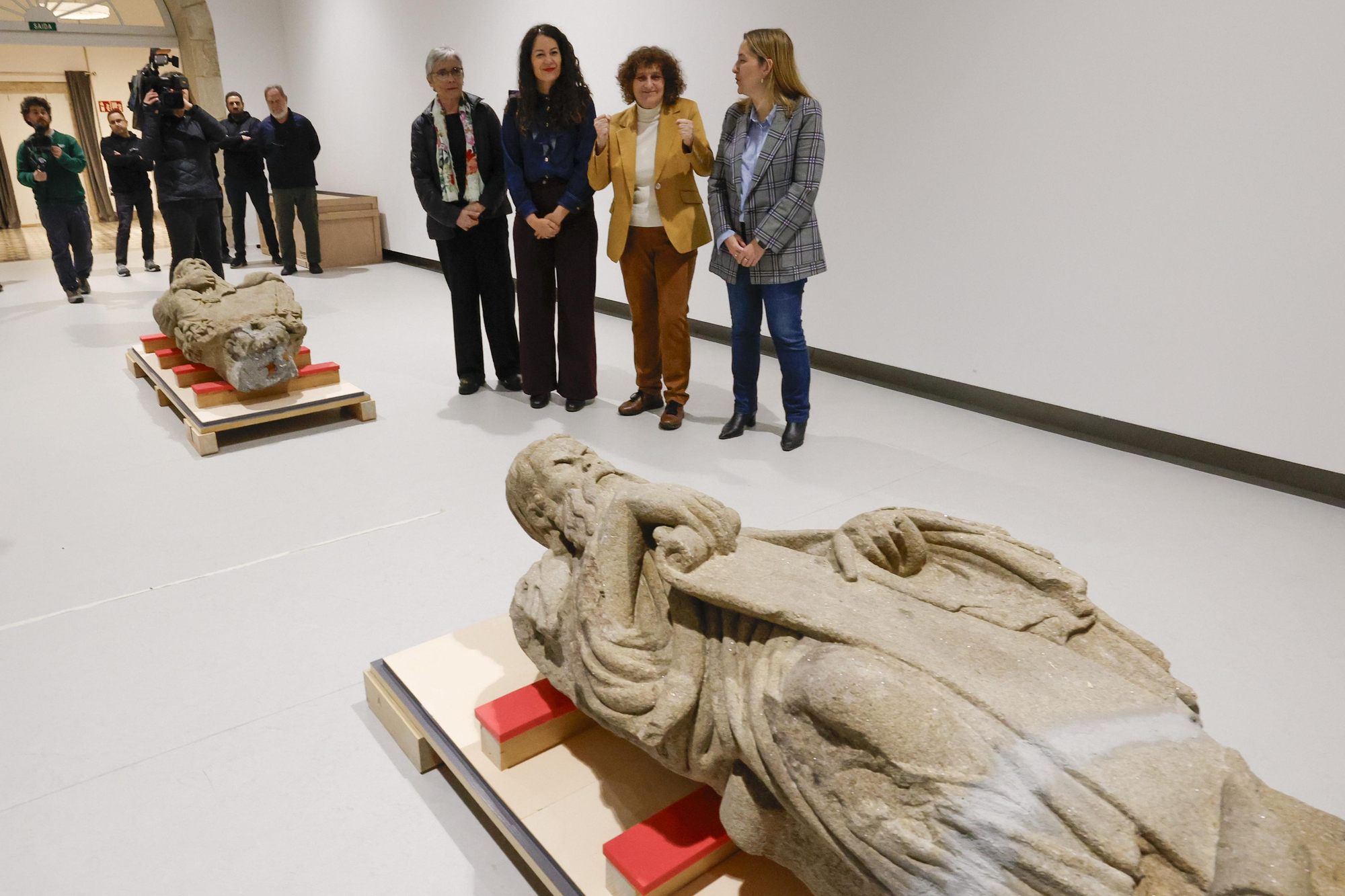 La alcaldesa de Santiago (de amarillo) alza los puños en señal de victoria. En primer plano, Ezequiel con la fractura que no vio la Audiencia Provincial de Madrid