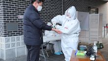 Un hombre se somete a un control de temperatura antes de entrar en un colegio electoral durante las elecciones generales de Corea del Sur.