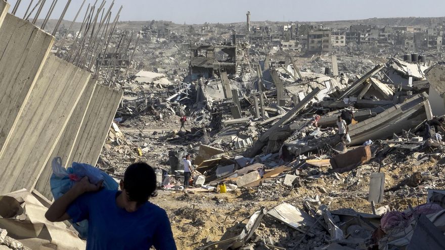 Algunos palestinos buscan sus pertenencias entre los escombros en Ciudad de Gaza tras el inicio del alto el fuego.