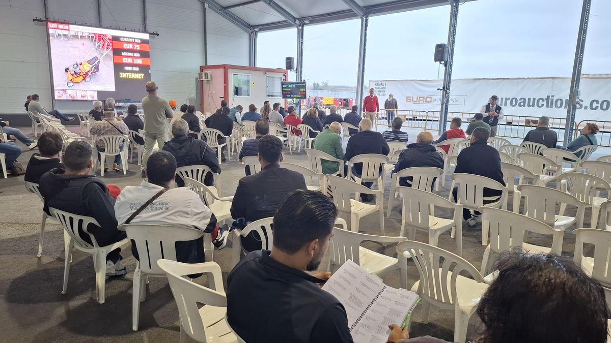 Un momento de la subasta en la gran nave, por la que enfrente van circulando los vehículos.