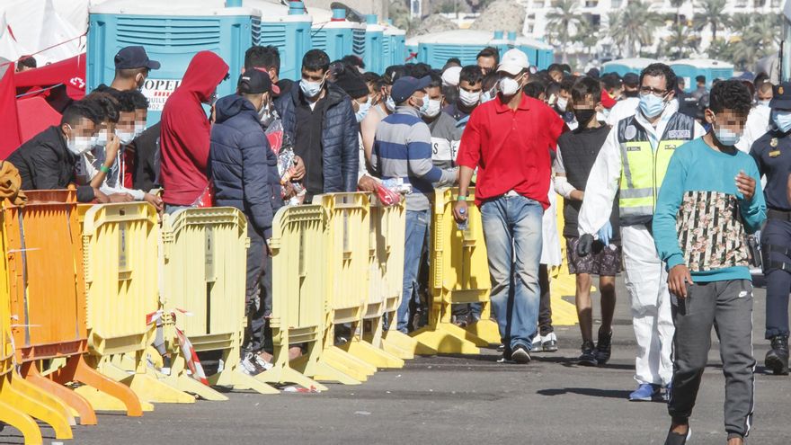 Varios inmigrantes hacen cola en el Muelle de Arguineguín, en Gran Canaria