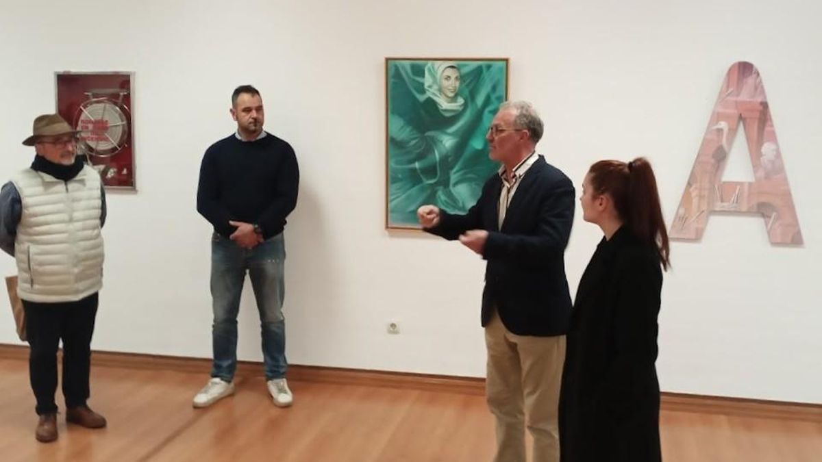 Adolfo Álvarez Barthe explicando su obra con el retrato de su madre al fondo.