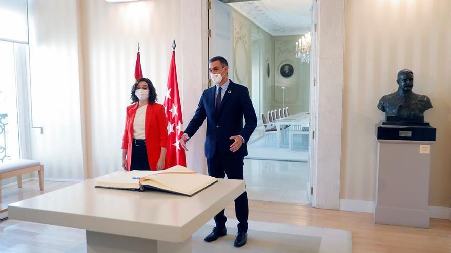La presidenta de la Comunidad de Madrid, Isabel Díaz Ayuso, y el jefe del Gobierno, Pedro Sánchez, se acercan a firmar el libro de autoridades, antes de mantener una reunión en la sede del Gobierno regional, este lunes en Madrid