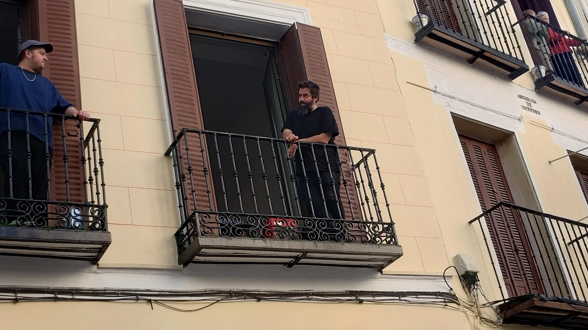 Un vecino de la plaza San Ildefonso enchufa un altavoz a su radio para dar a conocer las noticias en la plaza