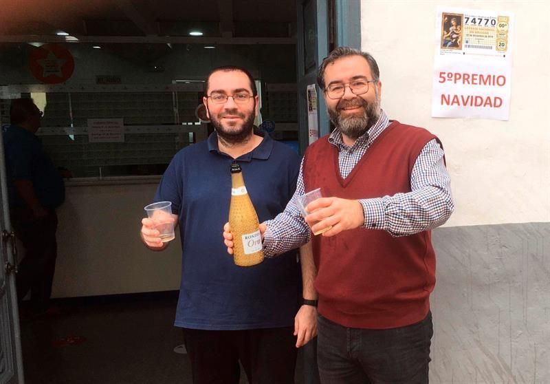 Ángel Alonso (d), empleado de la administración de Loterías nº2 de Santa Cruz de La Palma celebra haber repartido 150 décimos del número 74.770, más de 900.000€, uno de los quintos premios de la Lotería de Navidad de este año.