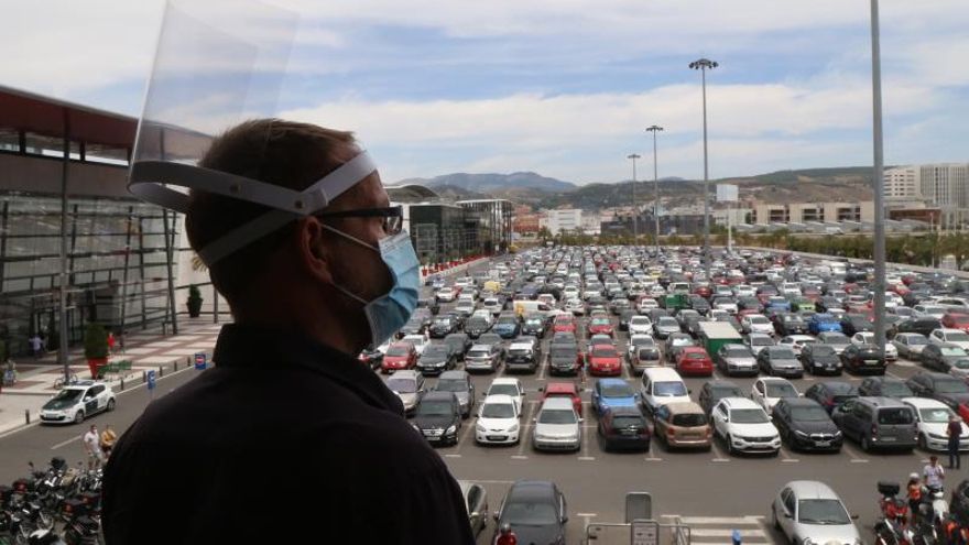 Un hombre observa los aparcamientos del Centro Comercial Nevada, en Armilla, Granada, que ha abierto sus puertas hoy lunes cuando esta provincia ha pasado a la fase 2 de la desescalada en el estado de alarma por la crisis sanitaria de la COVID-19.