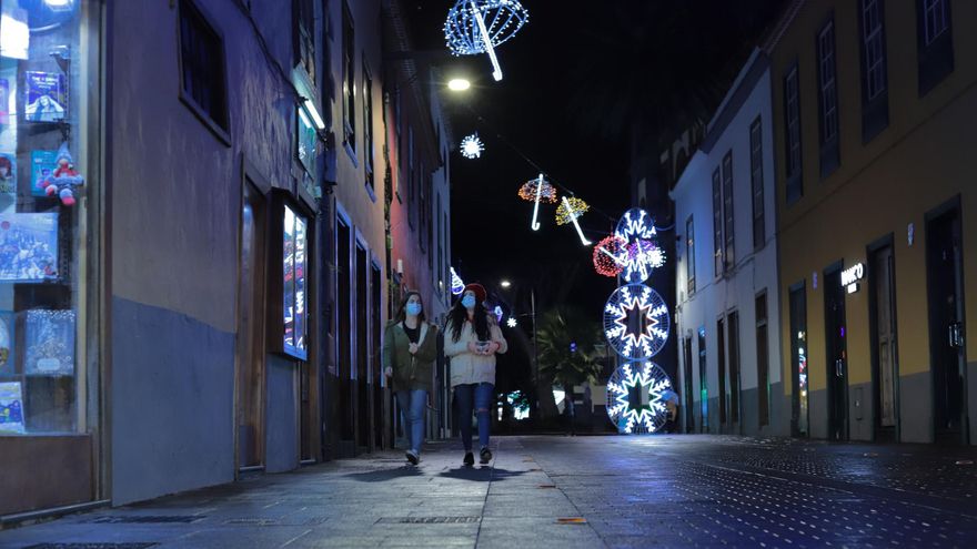 Varias personas pasean por las calles alumbradas de La Laguna