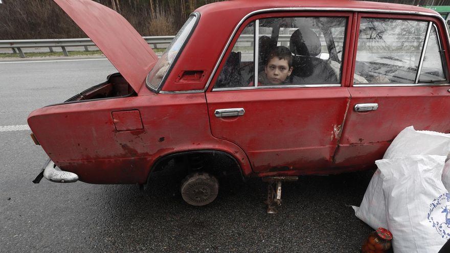 Bucha (Ukraine), 03/04/2022.- A Ukrainian boy looks out from the window of his family car a on a highway as they wait to change the tire, after fleeing from their village near Kyiv (Kiev), Ukraine, 03 April 2022. Dmitrivka and the area around had recently been recaptured by the Ukrainian army from Russian forces. On 24 February, Russian troops had entered Ukrainian territory in what the Russian president declared a 'special military operation', resulting in fighting and destruction in the country, a huge flow of refugees, and multiple sanctions against Russia. (Rusia, Ucrania)
